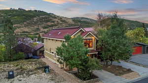 View of front of home with a metal roof, a mountain view, and a detached garage