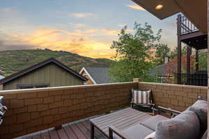 Balcony at dusk featuring a deck with mountain view