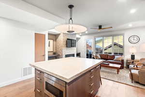 Kitchen featuring a kitchen island, open floor plan, light countertops, light wood finished floors, and recessed lighting