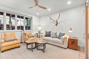 Living area with recessed lighting, a ceiling fan, a barn door, and wood finished floors