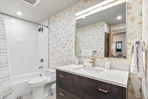 Full bath featuring shower / tub combo, wallpapered walls, vanity, and recessed lighting