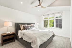 Bedroom with vaulted ceiling, ceiling fan, light colored carpet, and recessed lighting