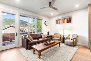 Living room with ceiling fan, light wood-type flooring, and recessed lighting
