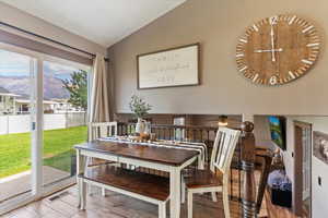 Dining area featuring wood finished floors, a mountain view, and vaulted ceiling