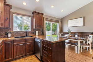 Kitchen featuring a peninsula, dark brown cabinets, recessed lighting, light wood-style floors, and tasteful backsplash