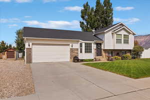 Split level home with brick siding, concrete driveway, and a garage