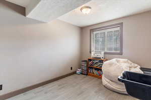 Living area featuring a textured ceiling and wood tiled floors