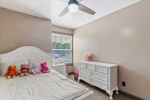 Bedroom with dark carpet and ceiling fan
