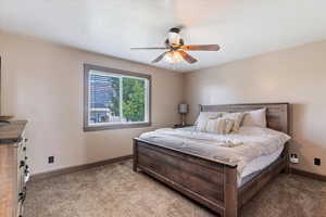 Carpeted bedroom with baseboards and ceiling fan
