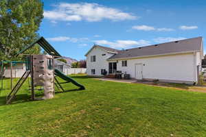 Rear view of property with a playground, a patio, and a mountain view
