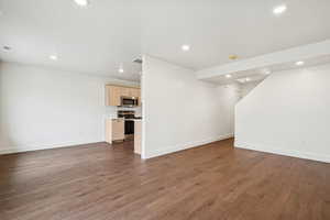 Unfurnished living room with recessed lighting and dark wood-style flooring