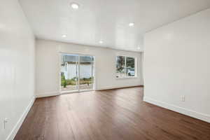 Spare room featuring dark wood-style floors, recessed lighting, and a textured ceiling