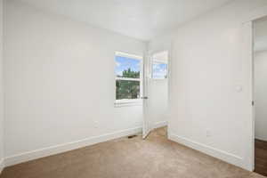 Unfurnished bedroom featuring baseboards and light colored carpet