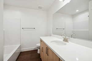 Full bath with dark wood-style floors, vanity, and recessed lighting