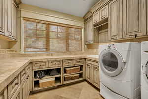 2nd floor Washroom with washing machine and clothes dryer, cabinet space, and light tile patterned flooring