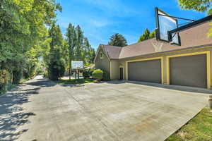 Pool House/ADU garagesView of property exterior with concrete driveway, a garage, board and batten siding, and roof with shingles