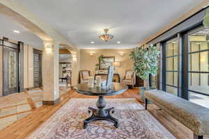 Foyer entrance with arched walkways, recessed lighting, healthy amount of natural light, and wood finished floors