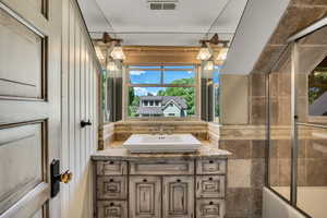 2nd floor Bathroom featuring vanity, shower / bath combination with glass door, and tile walls