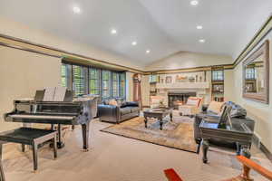 Carpeted living area featuring vaulted ceiling, recessed lighting, and a high end fireplace