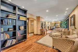 Living area featuring arched walkways, recessed lighting, and light wood-style floors