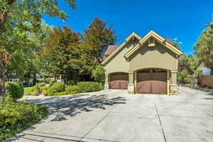 View of front of home featuring stone siding, driveway, and a garage