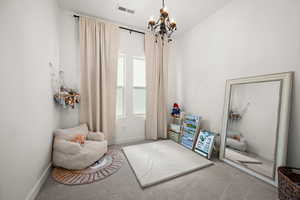Living area featuring carpet flooring and a chandelier