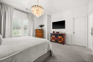 Bedroom with carpet flooring and a chandelier