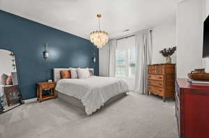 Bedroom with light carpet and a chandelier