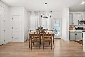 Dining room with a chandelier and light wood-style floors