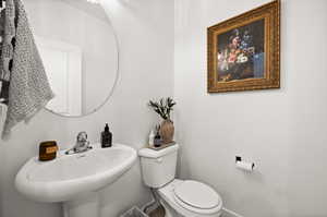 Half bathroom with toilet and baseboards