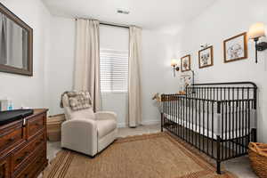 Bedroom featuring a crib and light colored carpet
