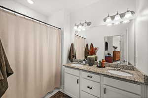 Full bathroom with double vanity, light tile patterned floors, a shower with curtain, and recessed lighting