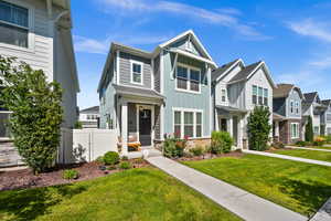 View of front of property featuring board and batten siding, a residential view, and stone siding