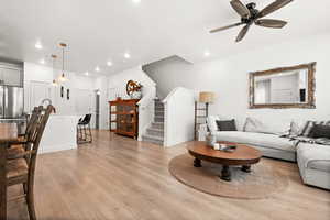 Living area with light wood-type flooring, stairway, recessed lighting, and ceiling fan