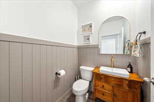 Half bath featuring vanity and wainscoting