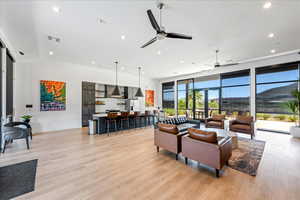 Living room with light wood finished floors, recessed lighting, and a ceiling fan