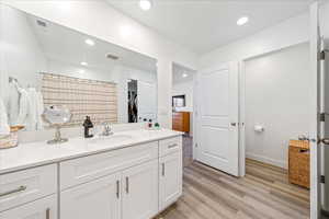 Full bath with vanity, a spacious closet, light wood-style floors, recessed lighting, and a shower with shower curtain