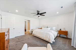 Bedroom featuring light colored carpet, ceiling fan, recessed lighting, and ensuite bath
