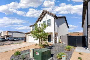 View of front of house featuring driveway, board and batten siding, and a gate