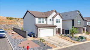 View of front of property featuring board and batten siding, stone siding, concrete driveway, and a garage