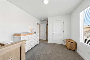 Bedroom with dark colored carpet and baseboards