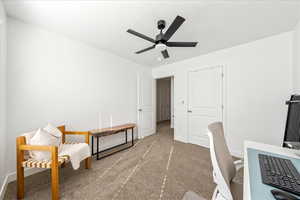 Carpeted office with ceiling fan and baseboards