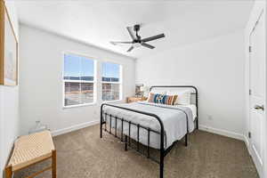Bedroom featuring carpet flooring, ceiling fan, and a textured ceiling