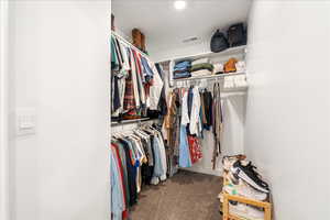 Spacious closet with dark colored carpet