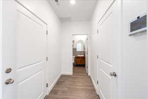 Hallway with dark wood-style floors and recessed lighting