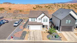 View of front of home with board and batten siding, a mountain view, stone siding, concrete driveway, and an attached garage