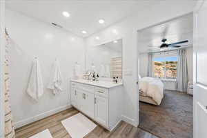 Ensuite bathroom with vanity, recessed lighting, light wood-style floors, and a ceiling fan
