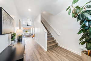 Stairway featuring wood finished floors and ceiling fan