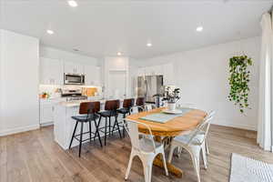 Dining area featuring light wood finished floors and recessed lighting