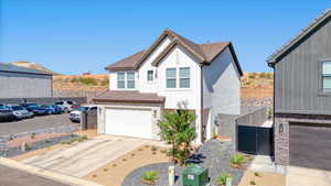 View of front of home featuring board and batten siding, stone siding, an attached garage, and concrete driveway